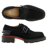 Black loafers with a buckle detail on a white background