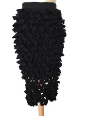 Black ruffled skirt on a mannequin against a white wall.