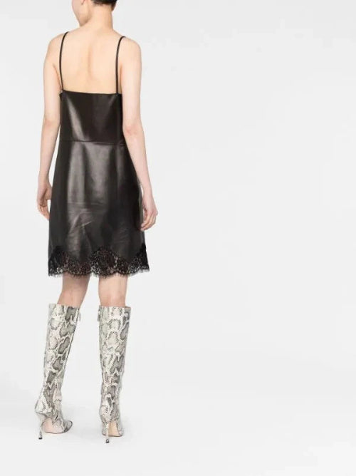 Person wearing a black slip dress with lace details and patterned knee-high boots on a white background