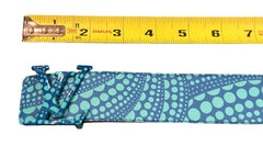 Blue patterned belt with a measuring tape showing its width on a brown surface