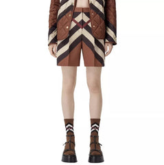 A pair of Burberry Rosalie Kissing Shorts in brown checkered pattern, paired with a brown quilted jacket and brown platform shoes.