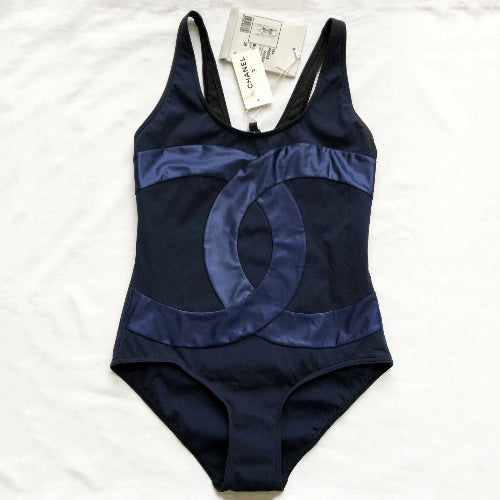 Navy blue swimsuit with brand tag on a white background