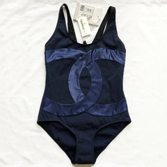 Navy blue swimsuit with brand tag on a white background