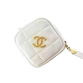 White quilted wallet with gold CC logo on a black surface
