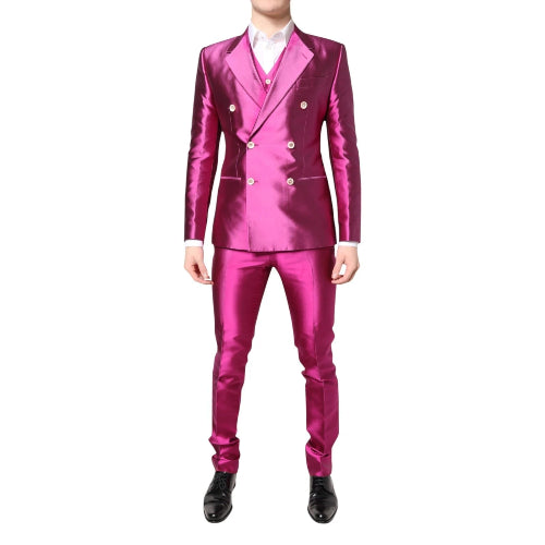 A male model wearing a pink double-breasted, notched-lapel, slim fit pant suit with a matching pink shirt and black shoes.