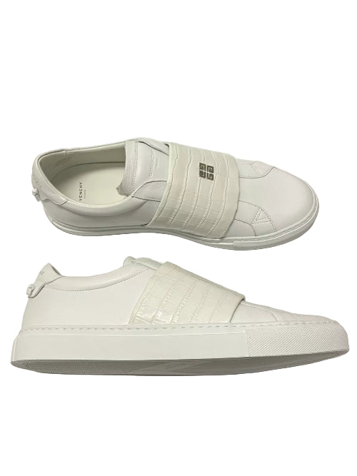 White slip-on sneakers with a plain background