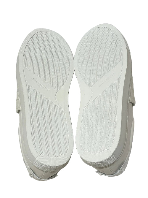 White sneakers with soles facing up on a white background