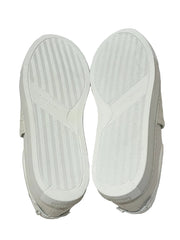 White sneakers with soles facing up on a white background