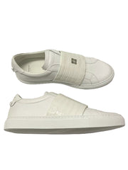 White slip-on sneakers with a plain background