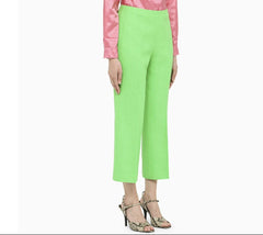 Person wearing bright green pants with a pink top on a white background