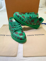 Green checkered high-top sneakers on a Louis Vuitton pouch with a brown box in the background.
