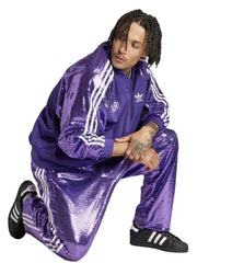 Person wearing a purple Adidas tracksuit on a white background
