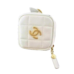 White quilted pouch with gold CC logo on a black box