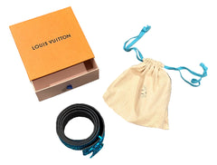 Louis Vuitton packaging with a belt and drawstring bag on a checkered floor.