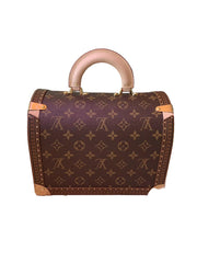 Designer handbag with monogram pattern on a pink surface