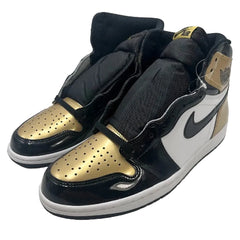 Black and gold sneakers with a prominent Nike logo on a white background