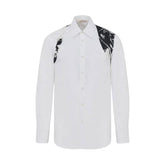A white long-sleeve button-up shirt with black and gray abstract graphic patterns on the right shoulder and sleeve, shown on a plain white background.