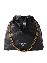 Black bag with gold chain and Balenciaga branding on a white background