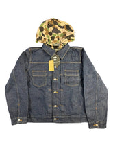 Denim jacket with a camouflage hood on a textured gray background