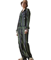 Person wearing a striped outfit with a hat on a plain background