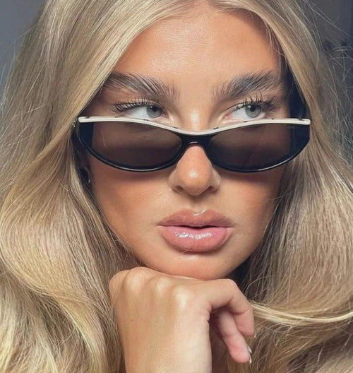 A close-up of a woman wearing dark rectangular sunglasses with a thin silver metal frame and a thick black lower rim.