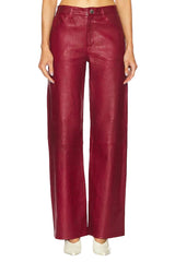 Red leather pants worn by a person on a white background