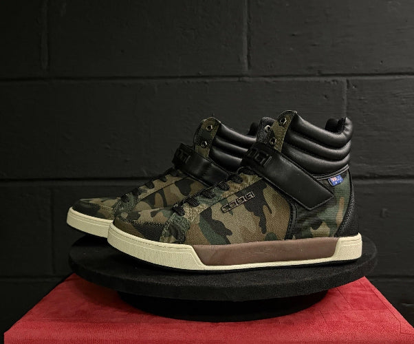 Camouflage high-top sneakers on a red platform with a black background