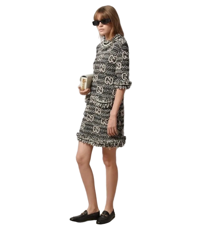 Woman wearing a patterned dress against a white wall
