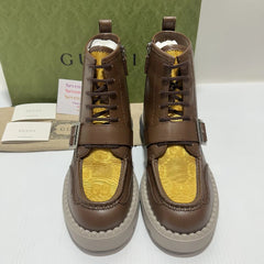 Brown high-top sneakers with yellow soles on a white surface, Gucci box and paper in the background.