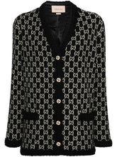 A Gucci black and beige GG monogram tweed cardigan with black fuzzy trim, buttoned front, and a visible Gucci label at the collar.