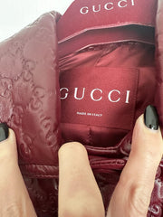 Close-up of a Gucci bag with a hand holding it, showing the brand logo.