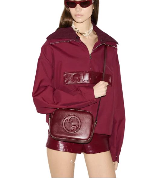 Gucci product page with a model wearing a red outfit and Gucci bag.