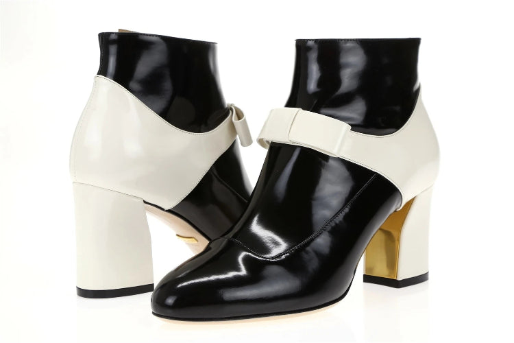 Black and white high-heeled shoes with bow details on a white background