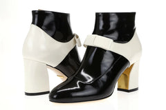 Black and white high-heeled shoes with bow details on a white background