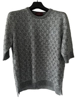 Gray patterned sweater on a hanger against a white background