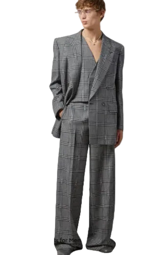 Man wearing a gray checkered suit against a plain background