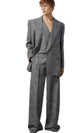 Man wearing a gray checkered suit against a plain background