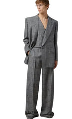 Man wearing a gray checkered suit against a plain background