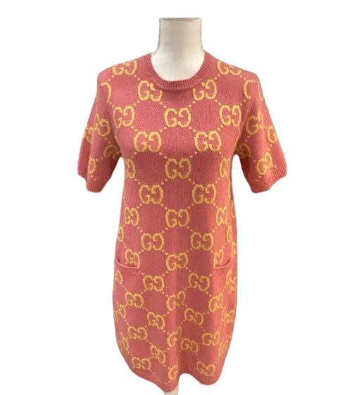 Red sweater with gold pattern on a mannequin against a gray background