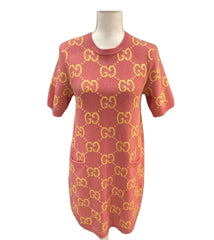 Red sweater with gold pattern on a mannequin against a gray background