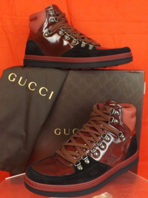 Gucci high-top sneakers with studded details on a Gucci box against an orange background
