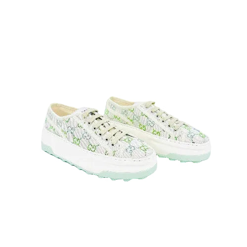 A pair of low-top lace-up sneakers in a light mint green and white colorway, featuring a textured knit upper and a chunky white sole with mint green detailing.