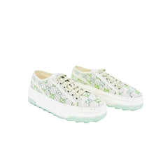 A pair of low-top lace-up sneakers in a light mint green and white colorway, featuring a textured knit upper and a chunky white sole with mint green detailing.