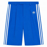 Blue shorts with white stripes and Adidas logo on a white background