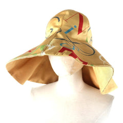 Gold bucket hat with colorful abstract patterns on a mannequin head against a white background