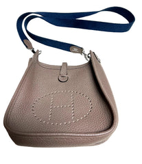 Beige handbag with a blue strap on a white background