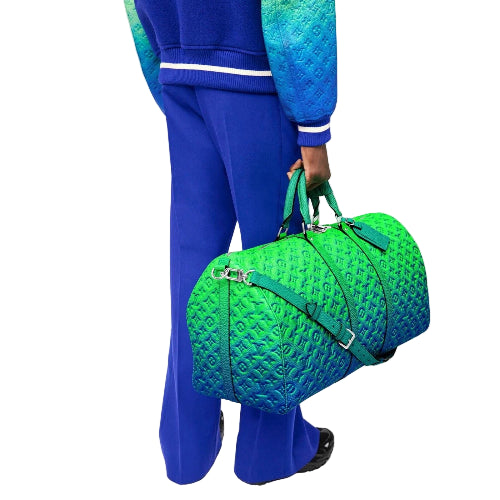 Person holding a green textured duffel bag against a white background