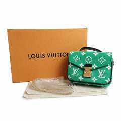 Green Louis Vuitton handbag with monogram pattern, box, and dust bag on a white background