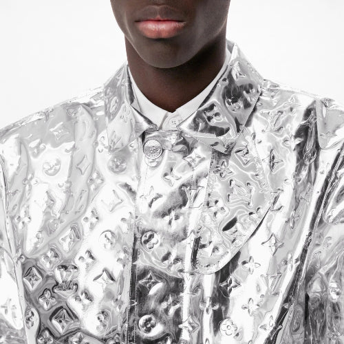 Silver reflective jacket with geometric patterns worn by a person on a white background