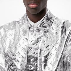 Silver reflective jacket with geometric patterns worn by a person on a white background